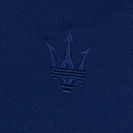 Close-up of the Maserati trident logo embroidered in dark blue thread on matching blue fabric.